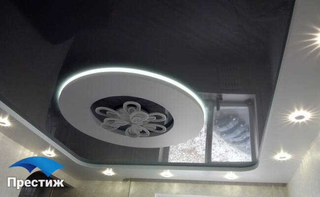Двухуровневый потолок с подсветкой выпуклого круга люстрой и светильниками